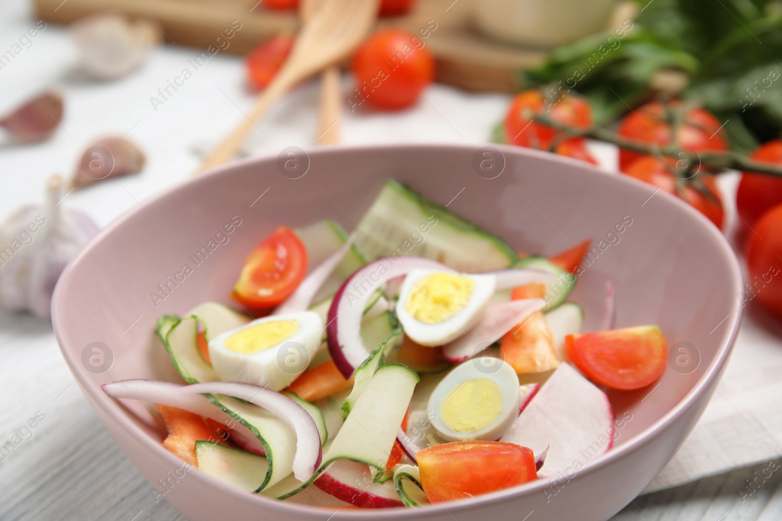 Photo of Bowl of delicious salad on white table, closeup