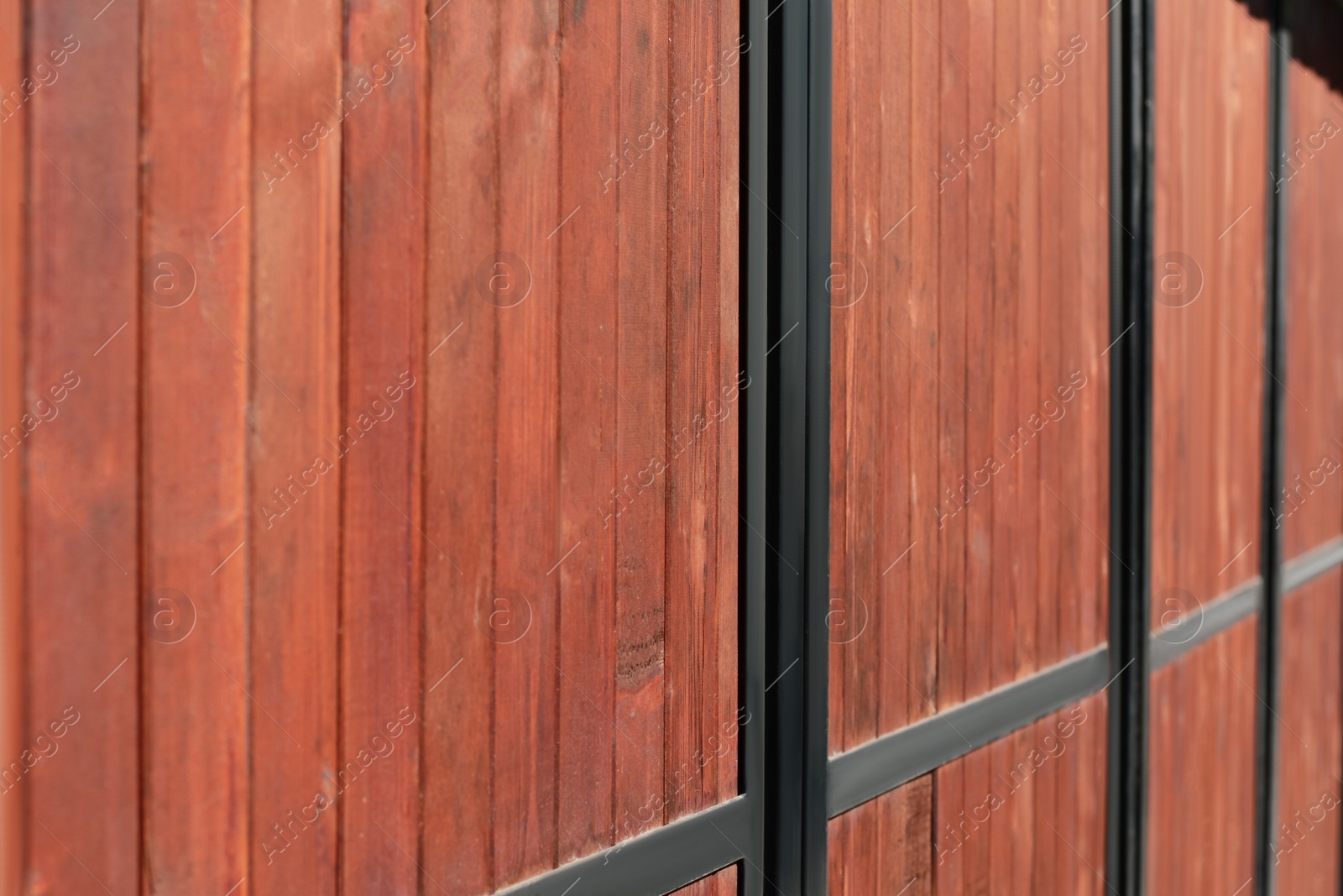 Photo of Metal and wooden fence outdoors, closeup view