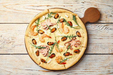 Photo of Delicious seafood pizza on white wooden table, top view