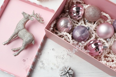 Composition with beautiful Christmas baubles on white wooden table, above view