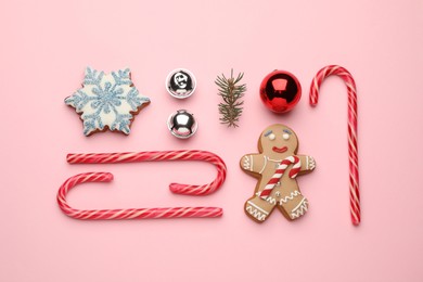 Flat lay composition with sweet candy canes and Christmas decor on pink background