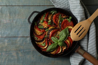 Delicious ratatouille on light blue wooden table, top view. Space for text