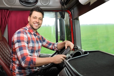 Photo of Professional driver sitting in cab of modern truck