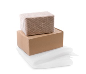 Cardboard boxes with bubble wrap and packaging foam on white background