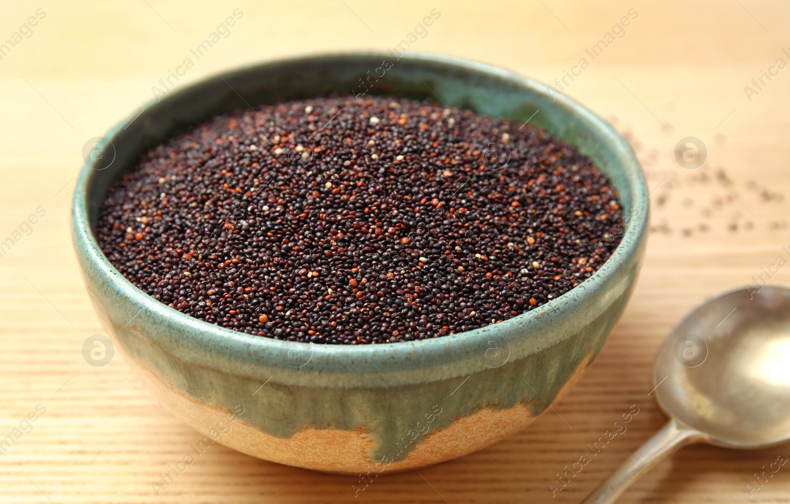 Photo of Bowl with black quinoa on wooden table