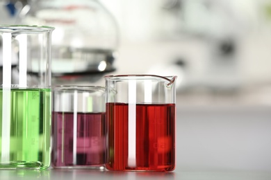 Image of Glass beakers with liquid samples on table. Laboratory analysis