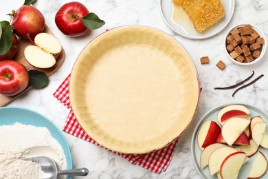 Photo of Flat lay composition with raw dough and ingredients on white marble table. Baking apple pie