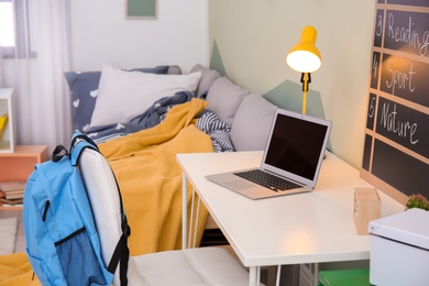 Photo of Modern child room interior with desk and laptop