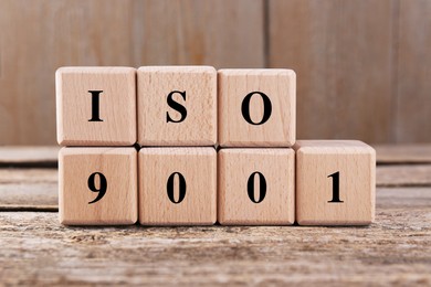 Photo of International Organization for Standardization. Cubes with abbreviation ISO 9001 on wooden table