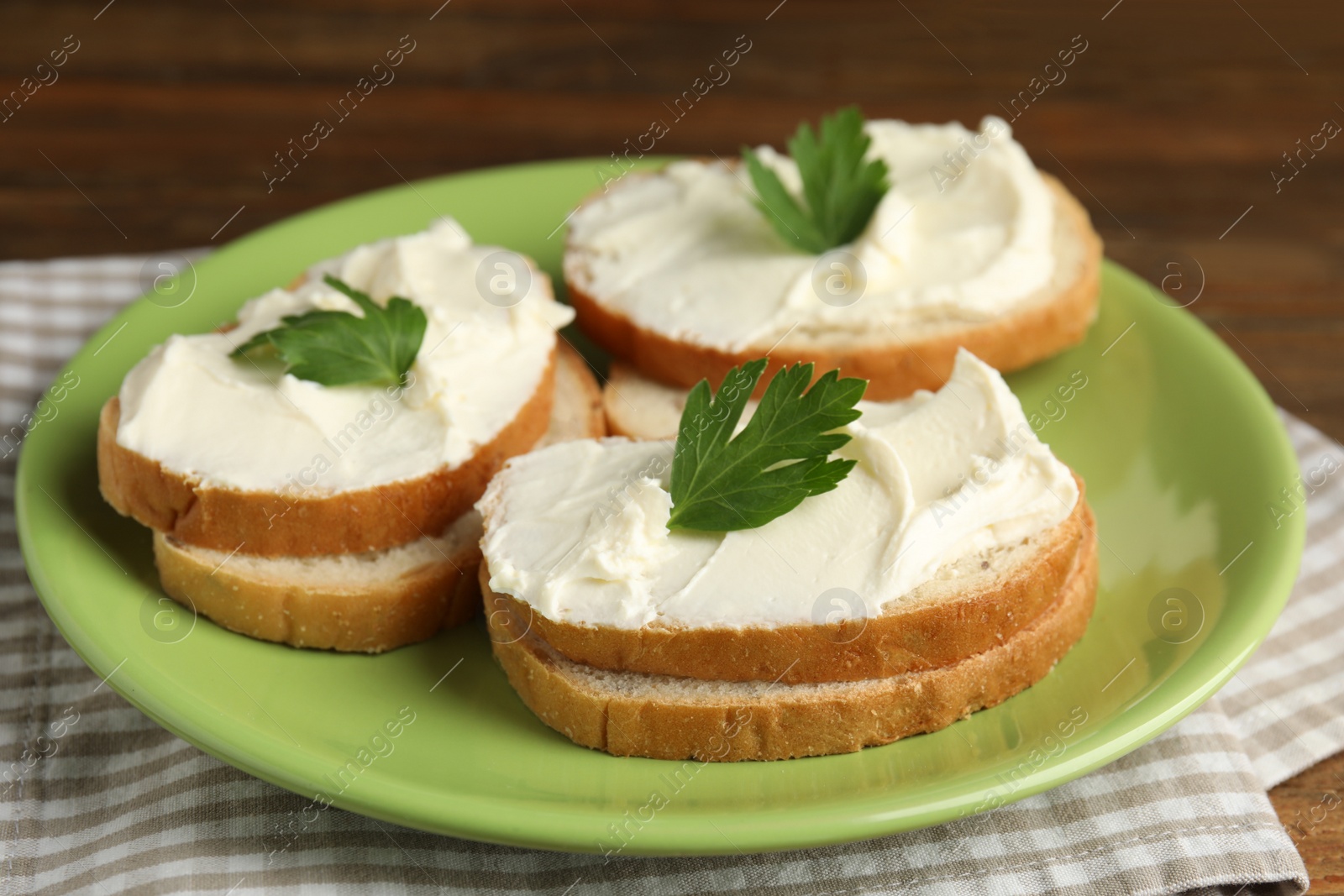 Photo of Bread with cream cheese and parsley on plate