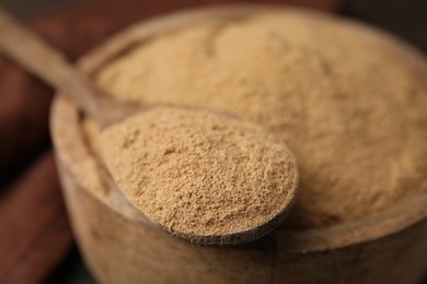 Photo of Dietary fiber. Psyllium husk powder in bowl and spoon on table, closeup