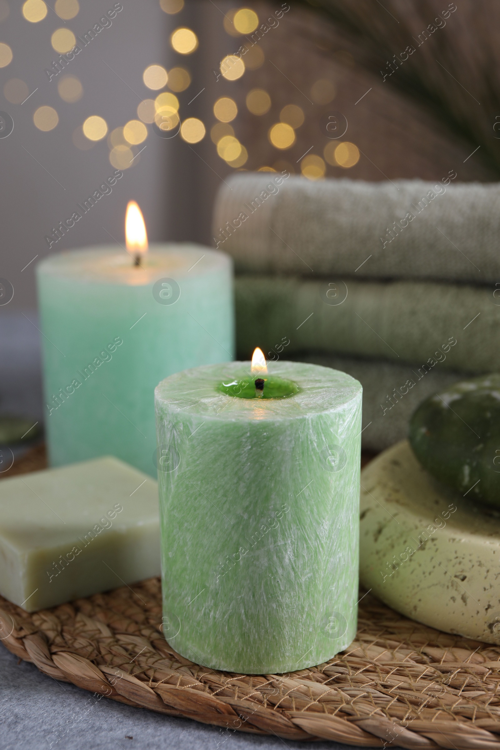 Photo of Spa composition with burning candles and soap on grey table, closeup