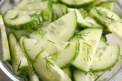 Photo of Cut cucumber with dill in glass bowl, closeup