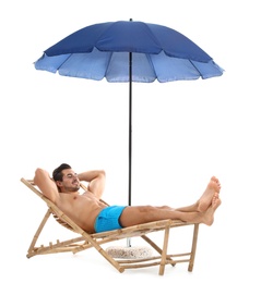 Photo of Young man on sun lounger under umbrella against white background. Beach accessories