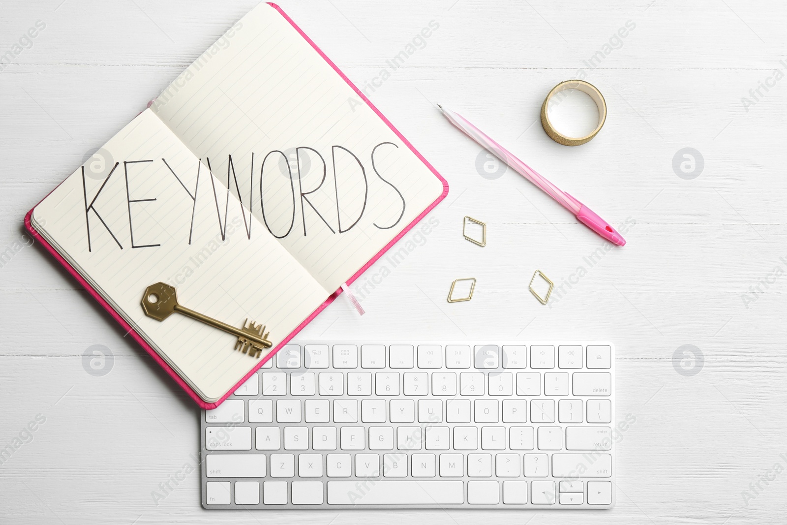 Photo of Composition with key, notebook and computer keyboard on white wooden table, flat lay. Keyword concept