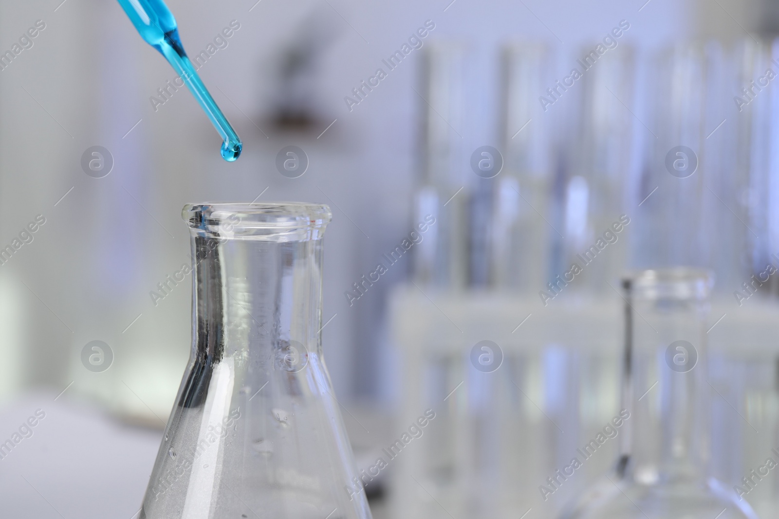 Photo of Laboratory analysis. Dripping liquid into flask on table, closeup. Space for text