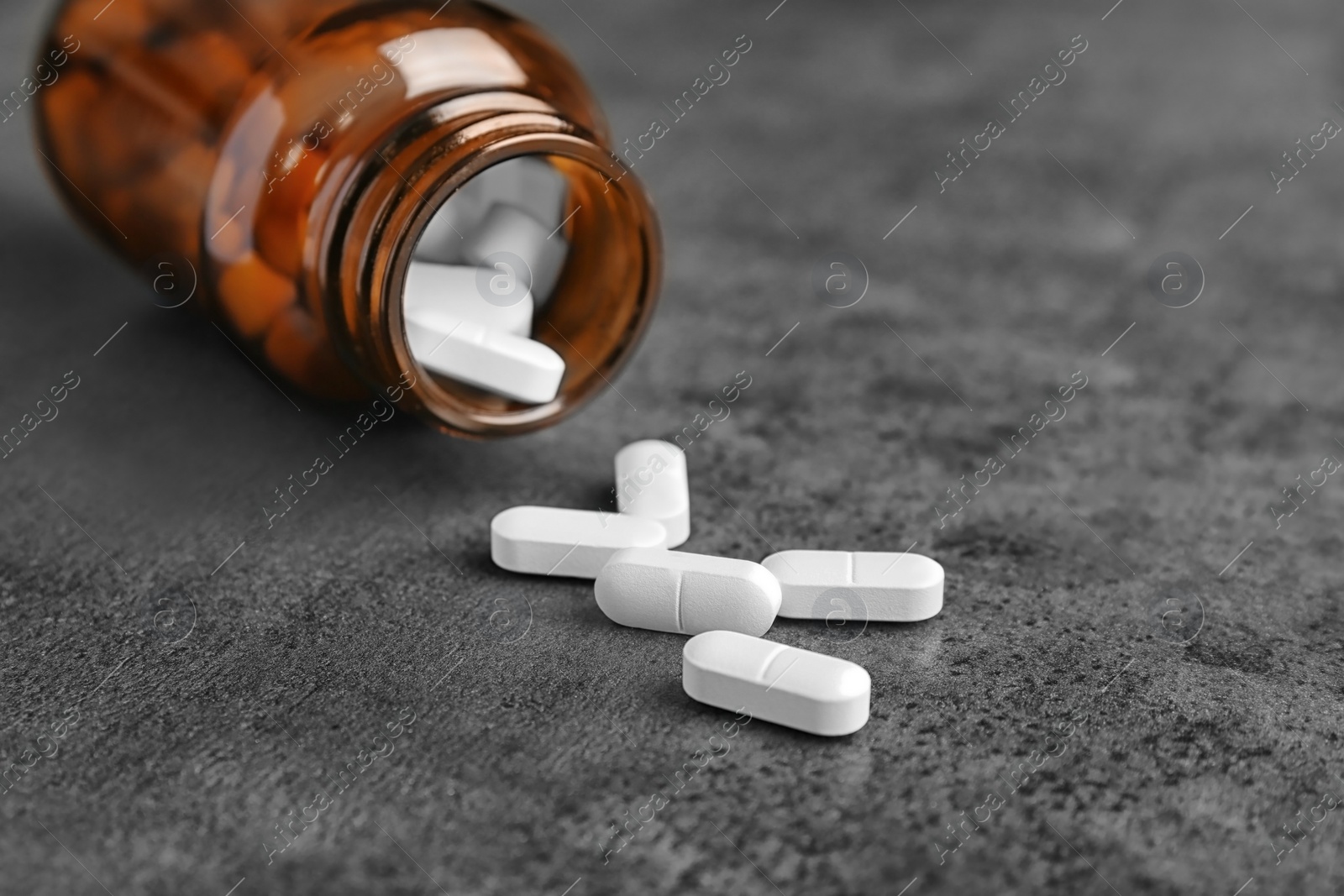 Photo of Bottle with pills on grey background