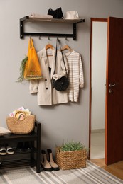 Photo of Hallway interior with stylish furniture, clothes and accessories