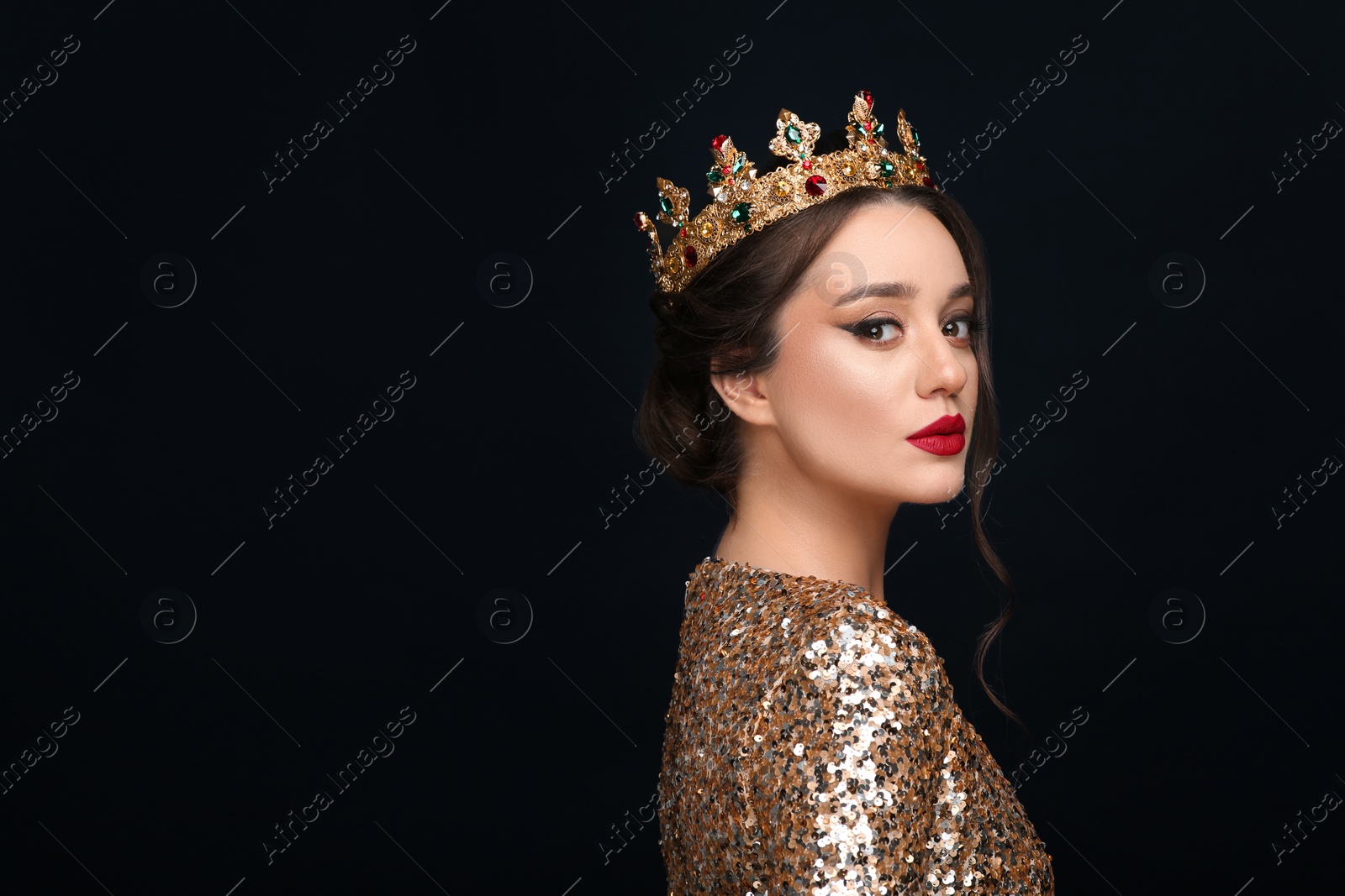 Photo of Beautiful young woman wearing luxurious crown on black background, space for text