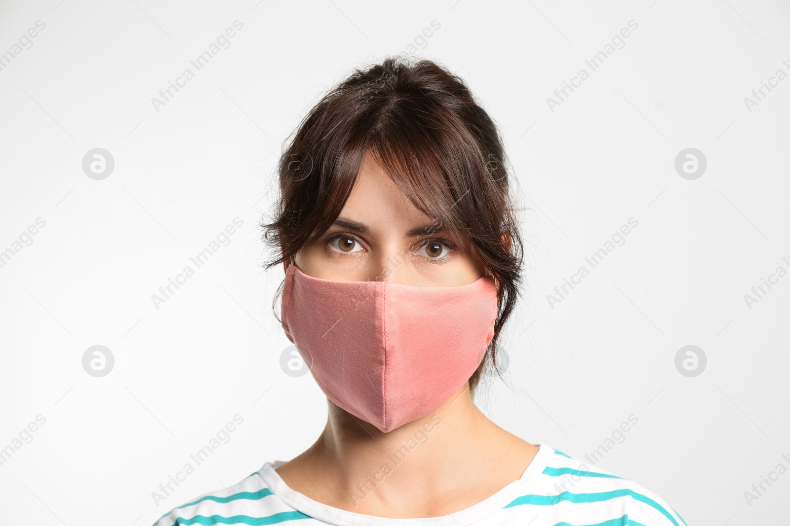 Photo of Young woman in protective face mask on light background