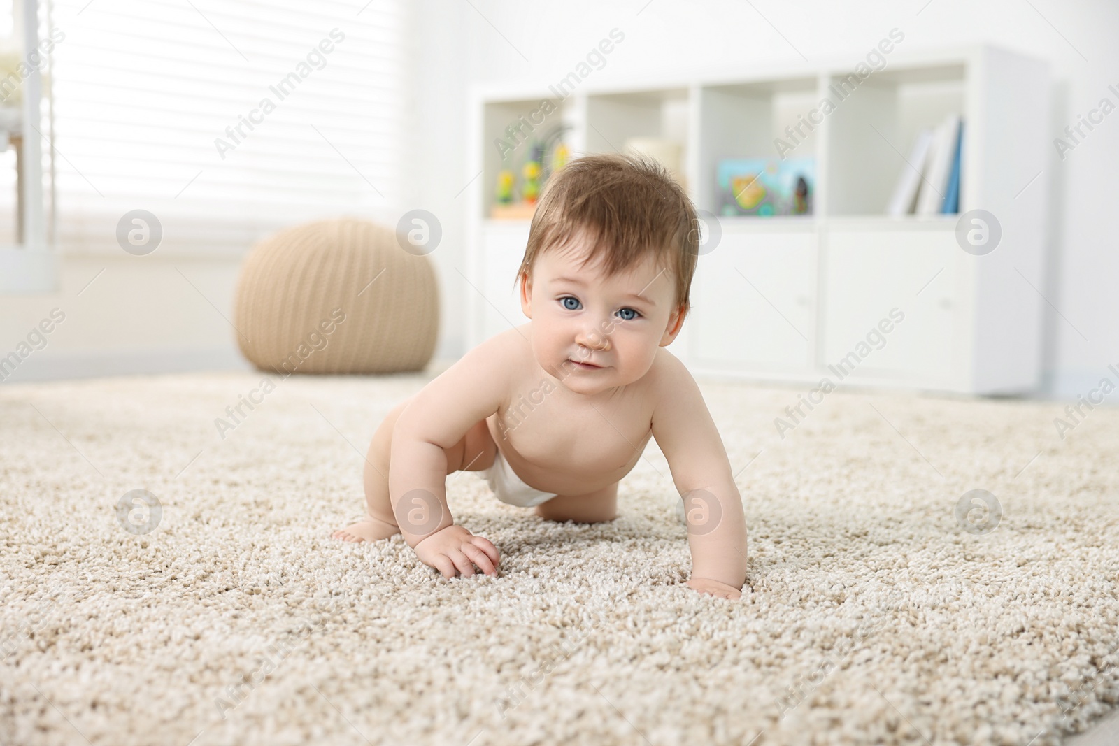 Photo of Cute baby boy crawling on carpet at home