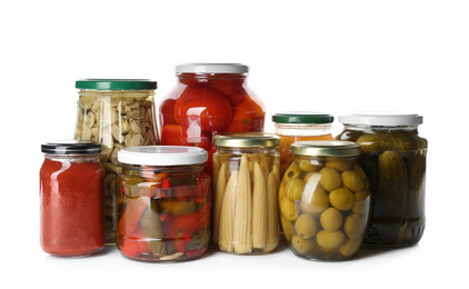 Glass jars with different pickled vegetables and mushrooms on white background