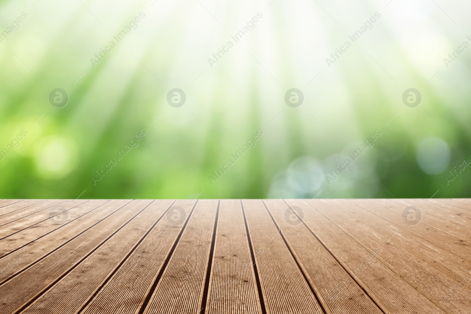 Image of Empty wooden surface against blurred green background. Bokeh effect