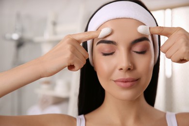 Photo of Woman using silkworm cocoons in skin care routine at home