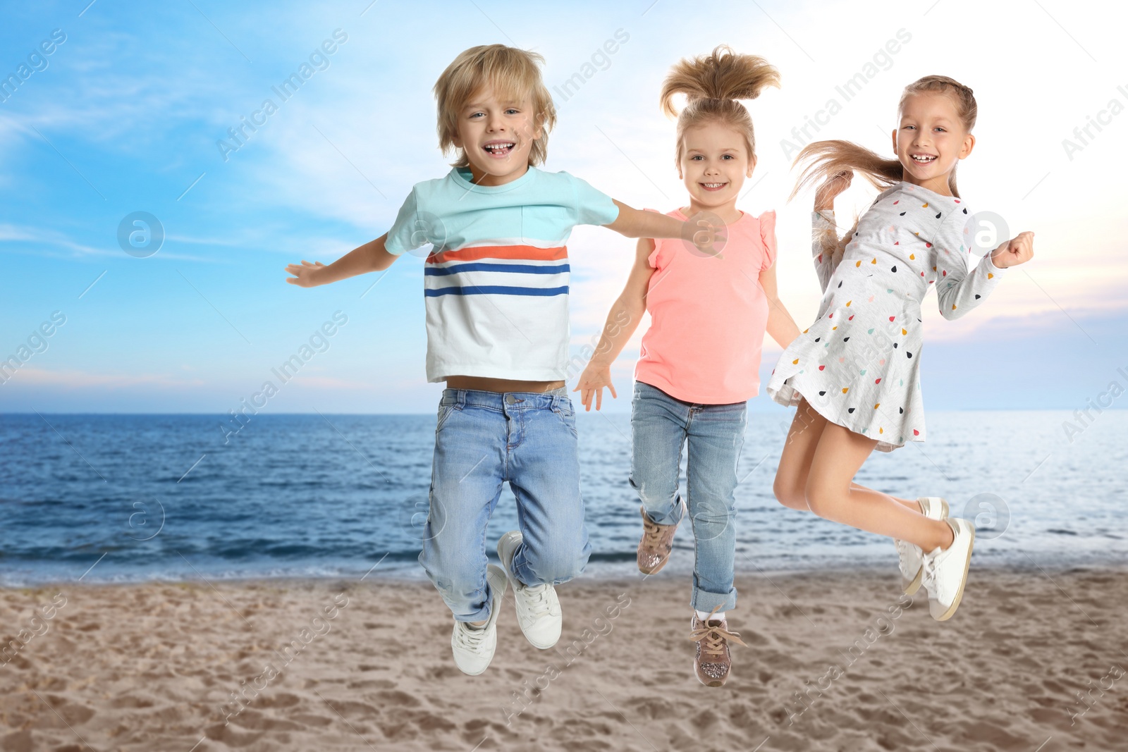 Image of Group of school children jumping on beach near sea. Summer holidays