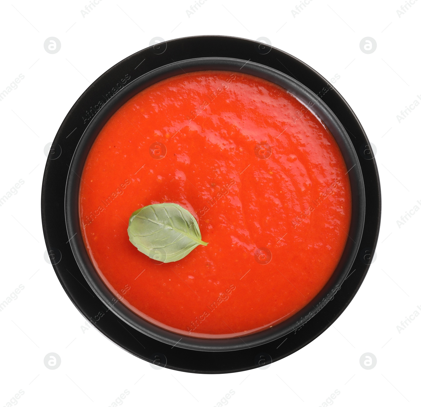 Photo of Delicious tomato cream soup in bowl isolated on white, top view