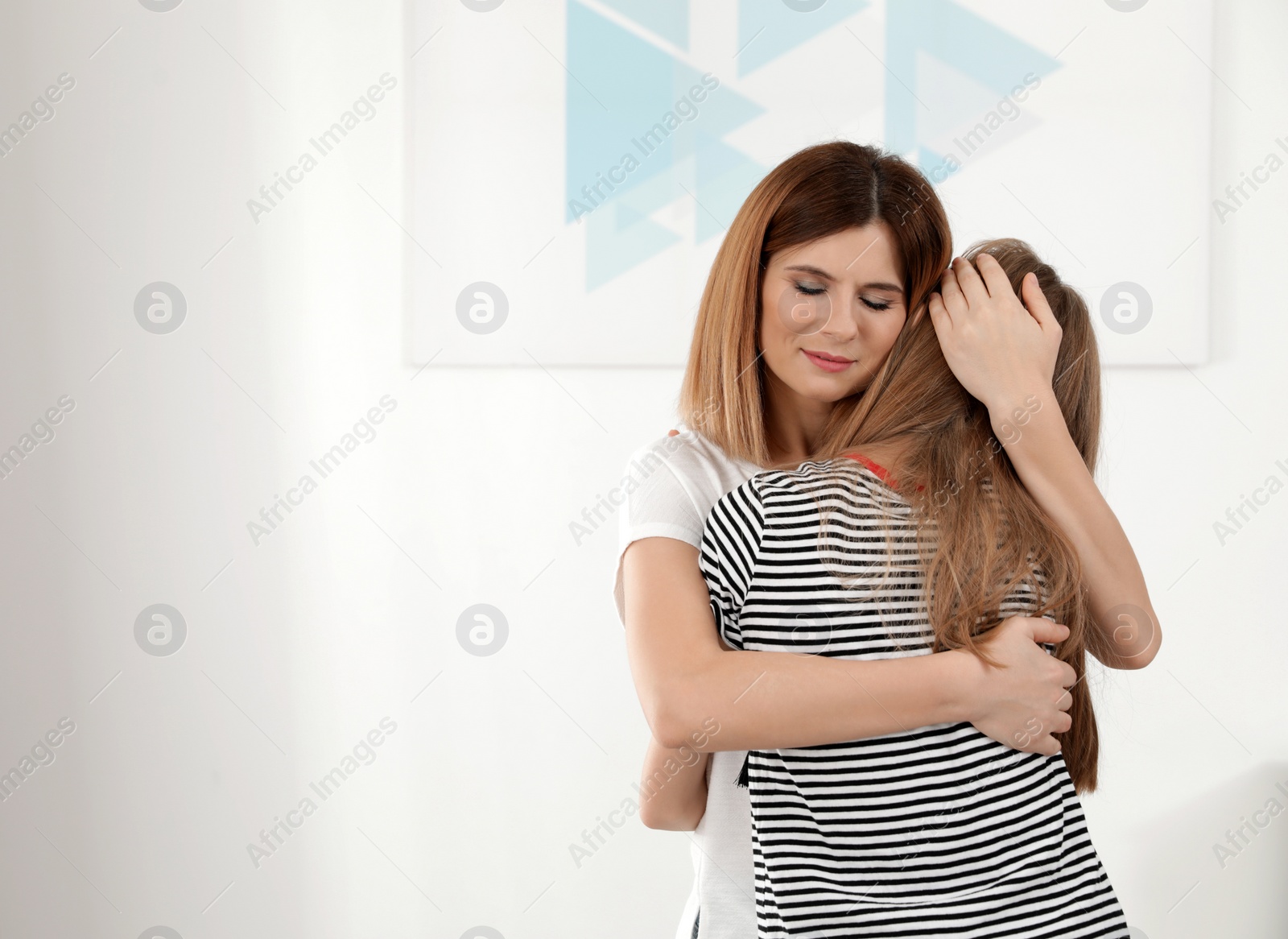 Photo of Happy mother hugging her teenager daughter at home