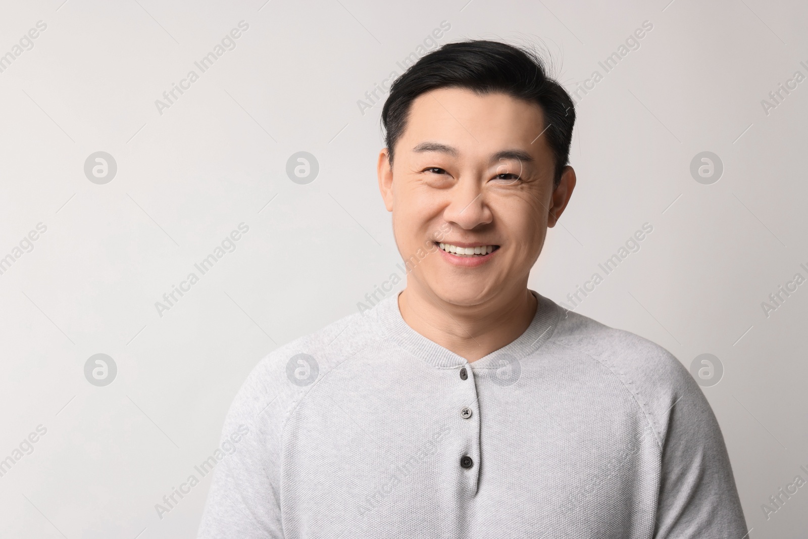 Photo of Portrait of happy man on light background. Space for text