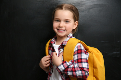 Cute little child near chalkboard. First time at school