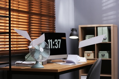 Modern electric fan and flying paper in office