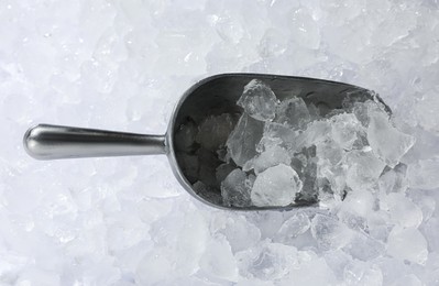 Metal scoop on crushed ice, top view