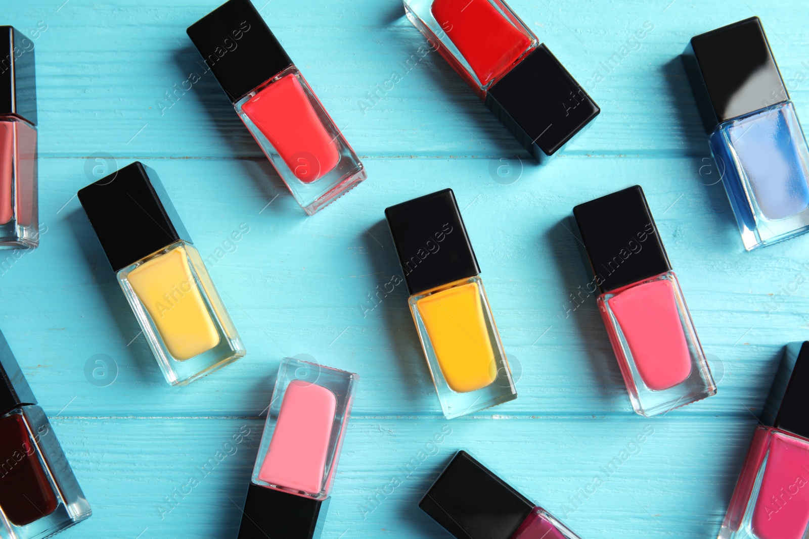 Photo of Bottles of nail polish on color background, top view