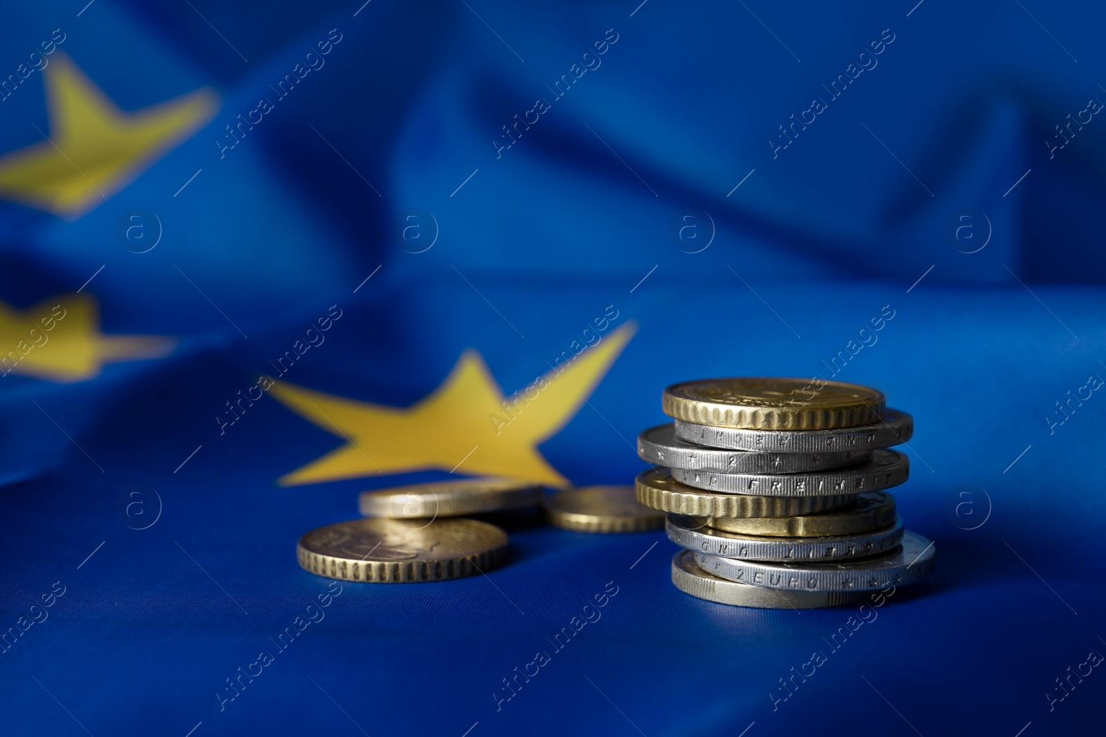 Photo of Many different coins on European Union flag, space for text