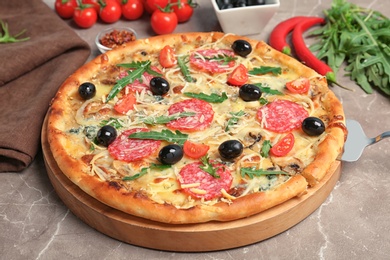 Delicious pizza with tomatoes and sausage  on table