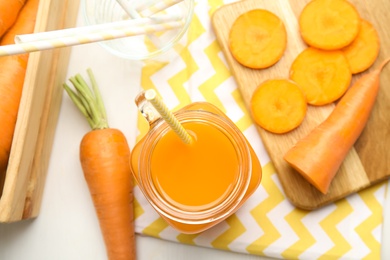 Photo of Freshly made carrot juice in mason jar on white table