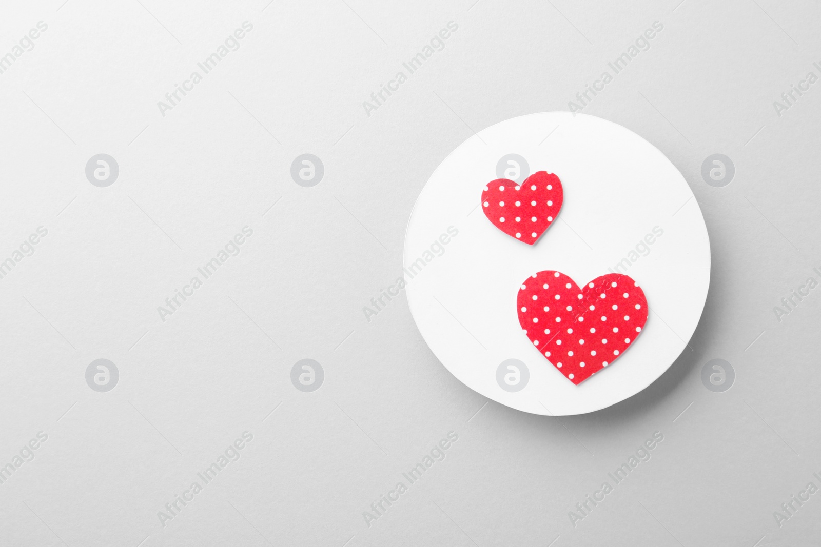 Photo of White card with decorative hearts on light background, top view