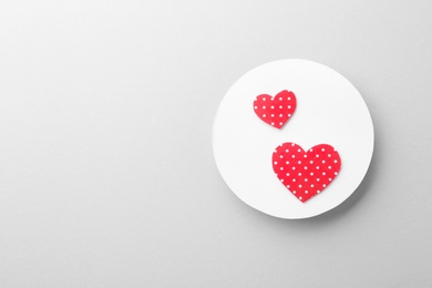 Photo of White card with decorative hearts on light background, top view
