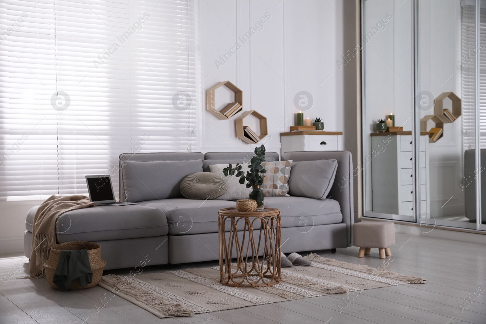 Photo of Living room with comfortable grey sofa and stylish interior elements near window