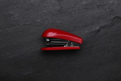 New bright stapler on black table, top view. School stationery