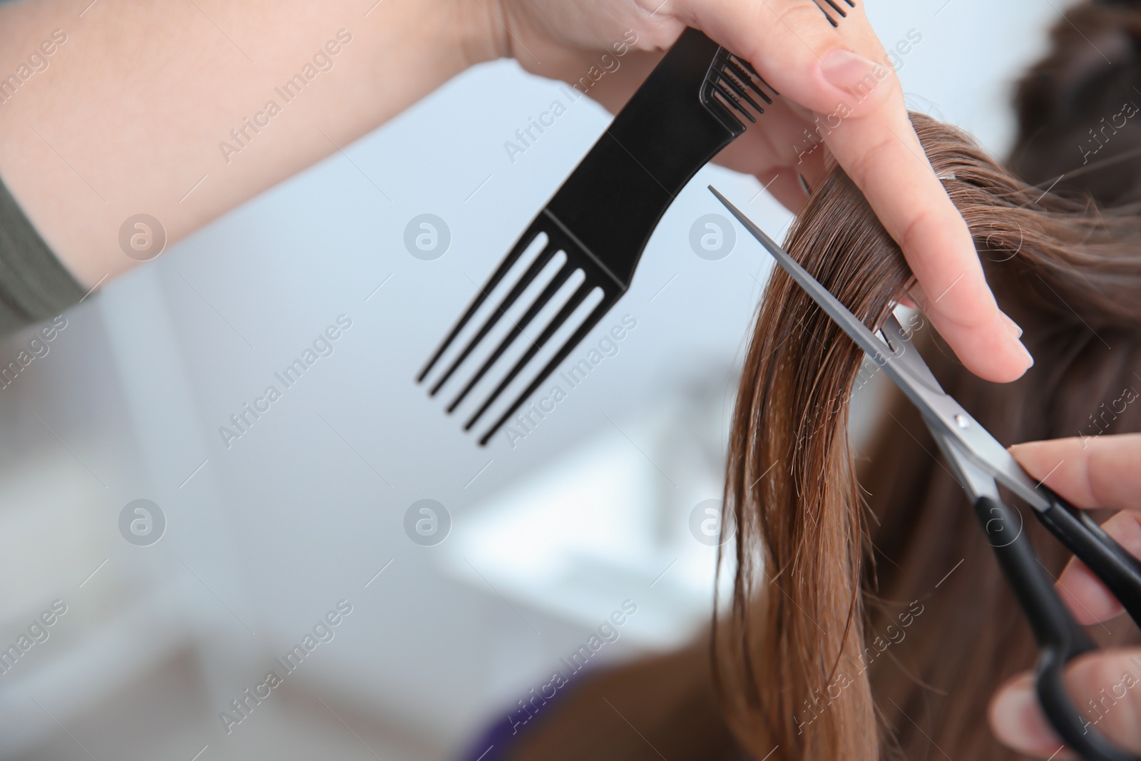 Photo of Professional hairdresser working with client in salon