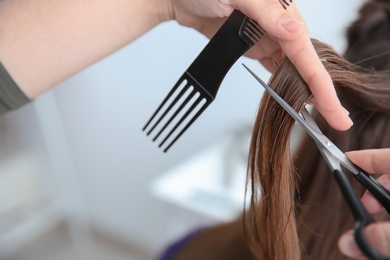 Photo of Professional hairdresser working with client in salon