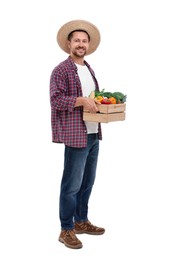 Harvesting season. Happy farmer holding wooden crate with vegetables on white background