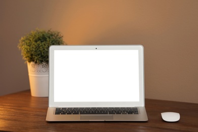 Laptop with blank screen on table indoors. Space for text