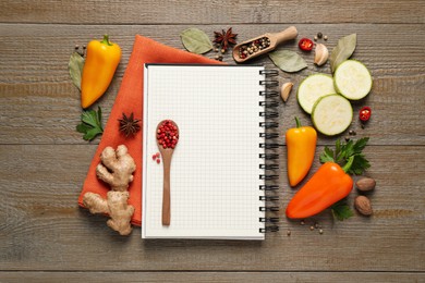 Blank recipe book and different ingredients on wooden table, flat lay. Space for text
