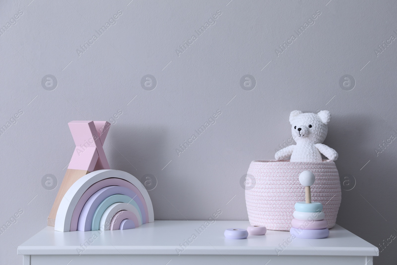 Photo of Child's toys on chest of drawers near light grey wall indoors