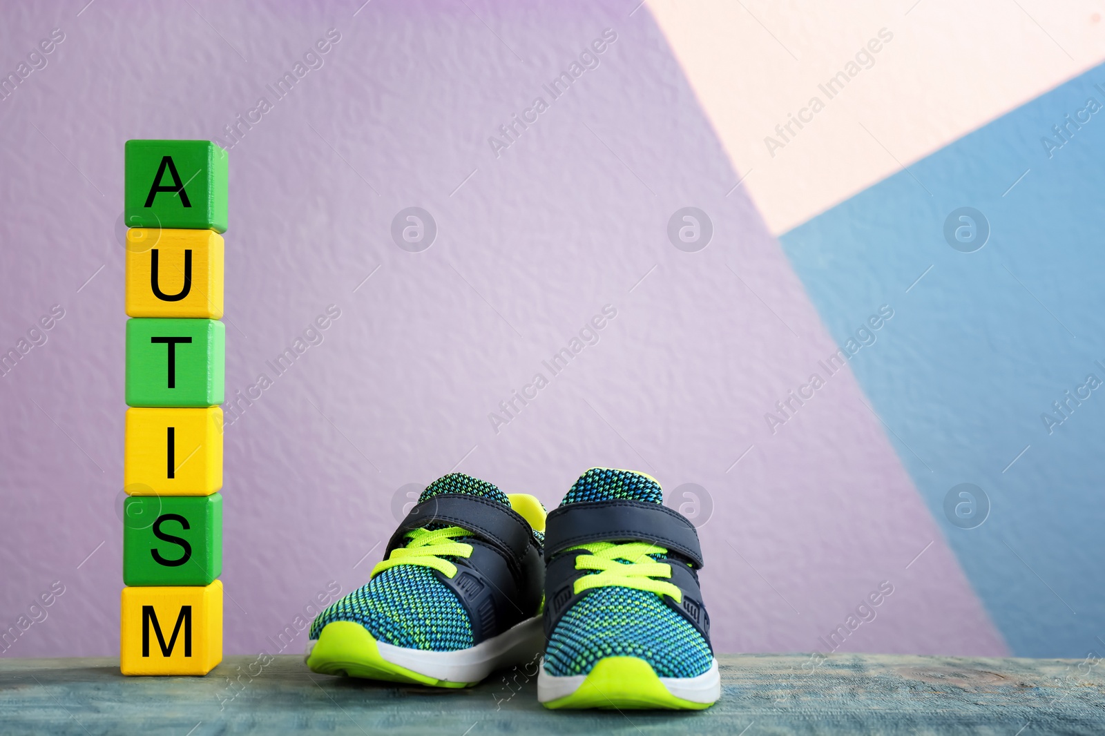 Photo of Training shoes and cubes with word "Autism" on table